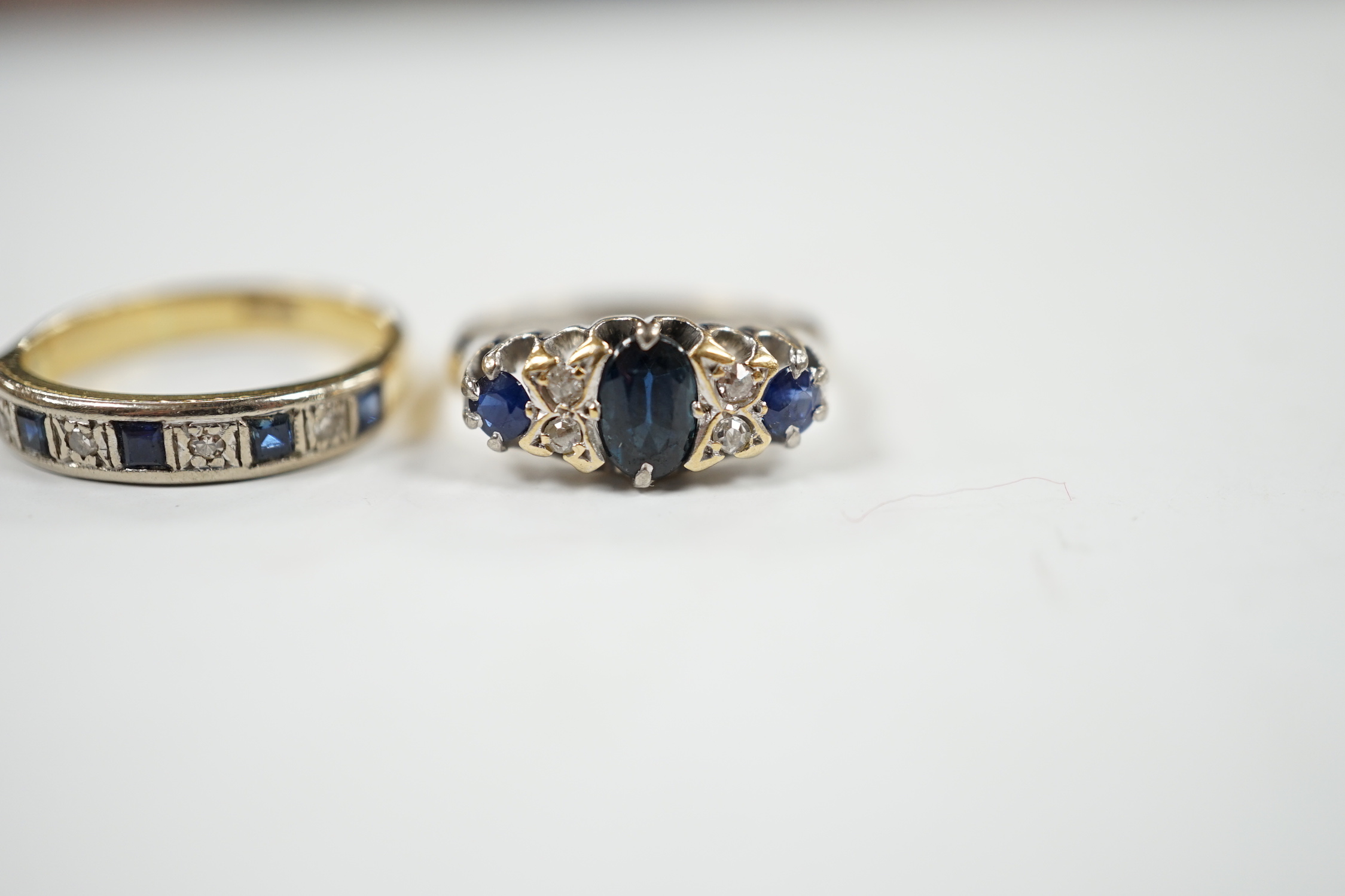 A George V 18ct white gold, sapphire and diamond cluster set ring, size K and one other 18ct, sapphire and diamond set half hoop ring, gross weight 7 grams.